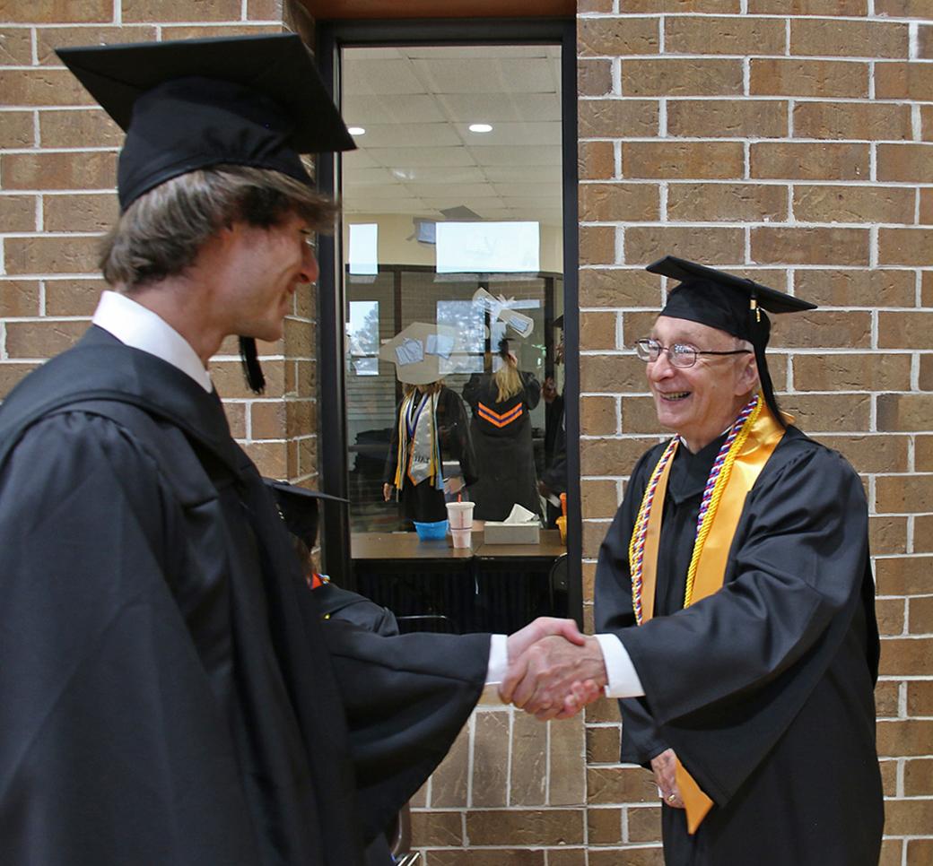 乔治·布雷迪 shakes hands with classmate at 2024 graduation ceremony